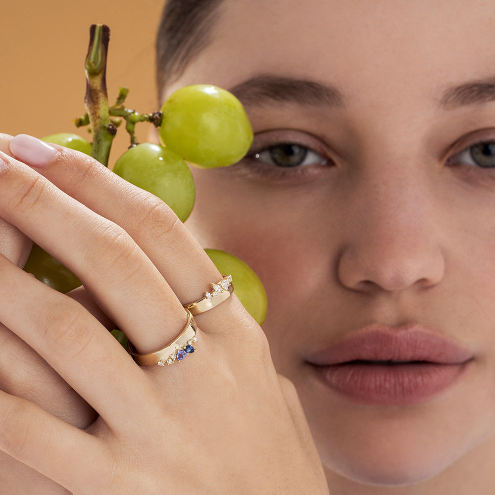 A wide gold ring with a special asymmetrical setting of diamonds in a variety of cuts.