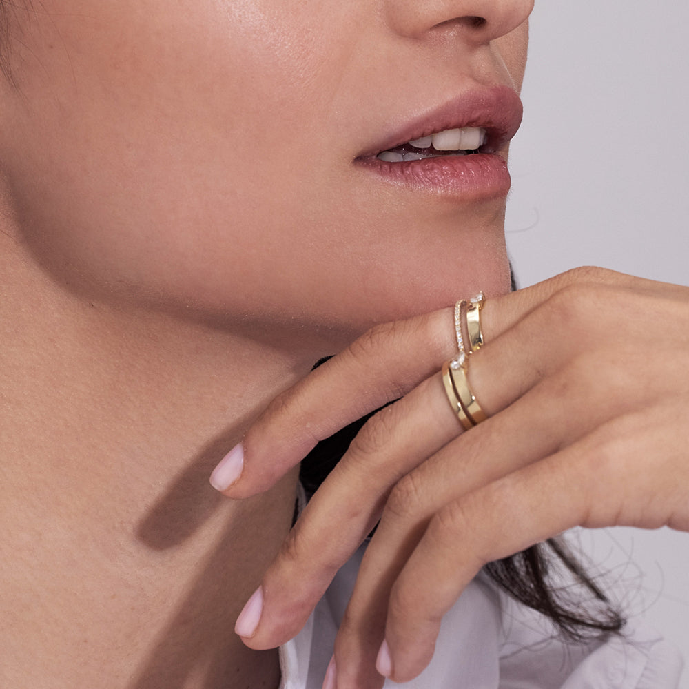 Double gold ring set with a row of diamonds and a 10-point drop-cut diamond