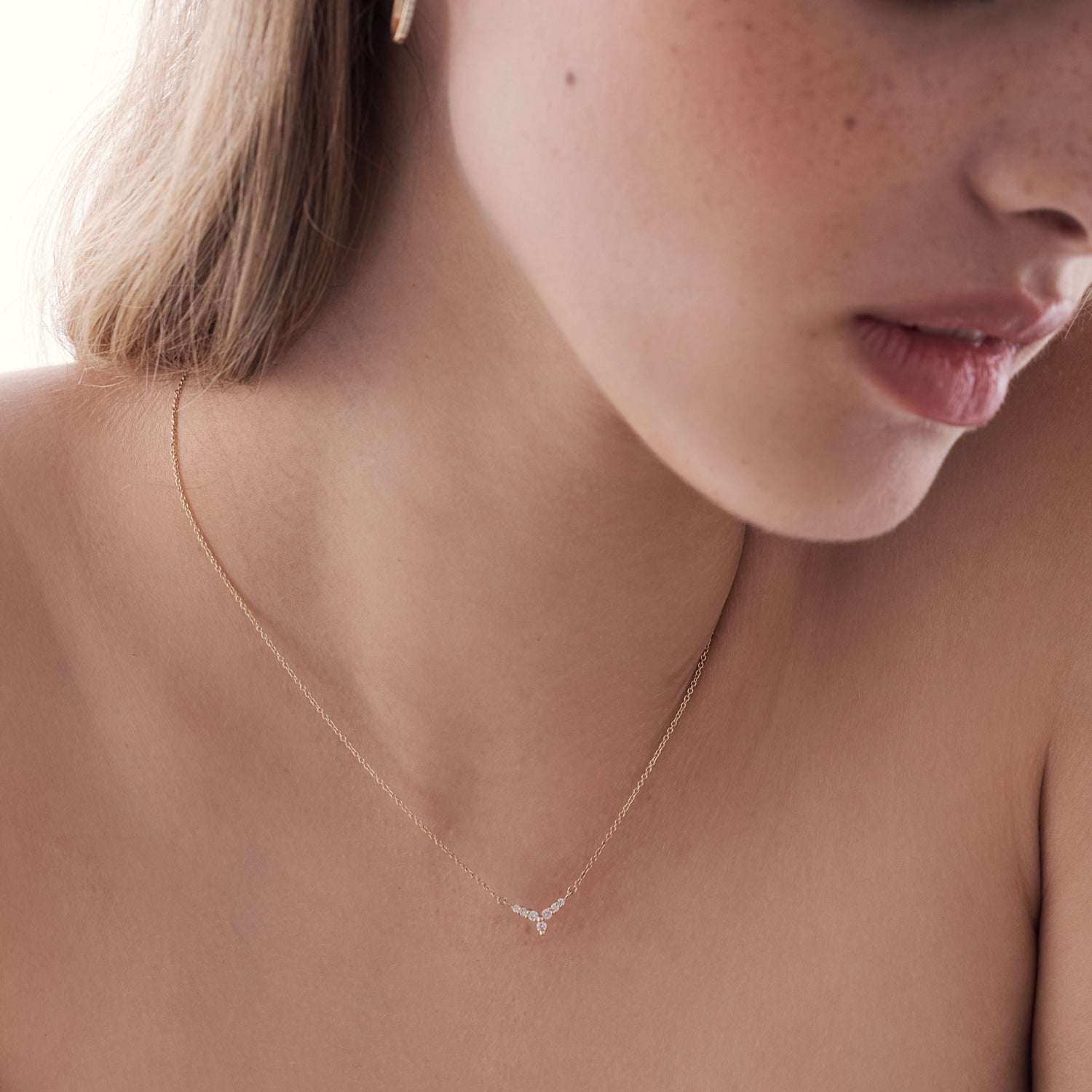 שרשרת זהב עם תליון בצורת וי משובץ יהלומים המזכירים פרח