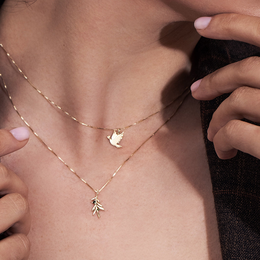 Gold necklace with a dove of peace and an olive leaf pendant