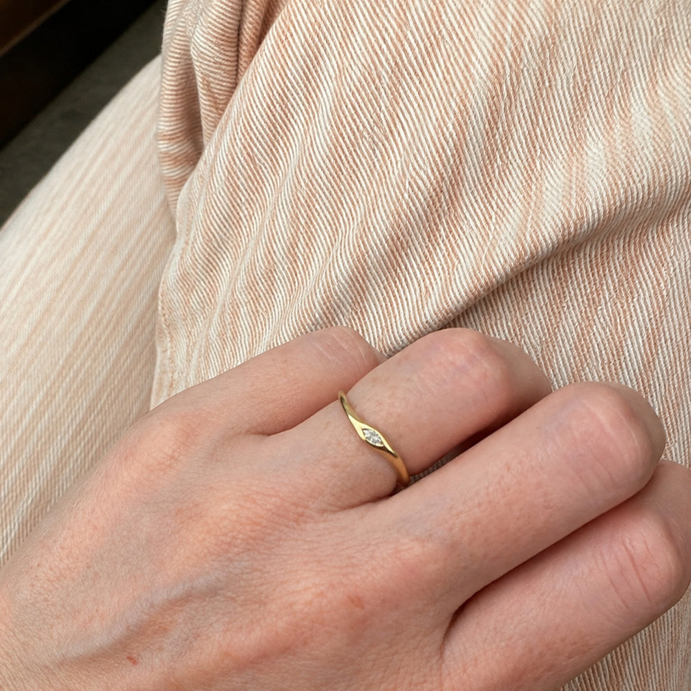 A delicate gold ring set with a marquise-cut lab-grown diamond