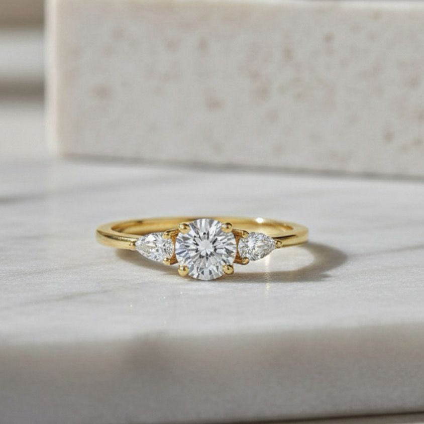 טבעת אירוסין משובצת יהלום מעבדה עגול (חצי קראט) ושני יהלומי מעבדה בחיתוך טיפה