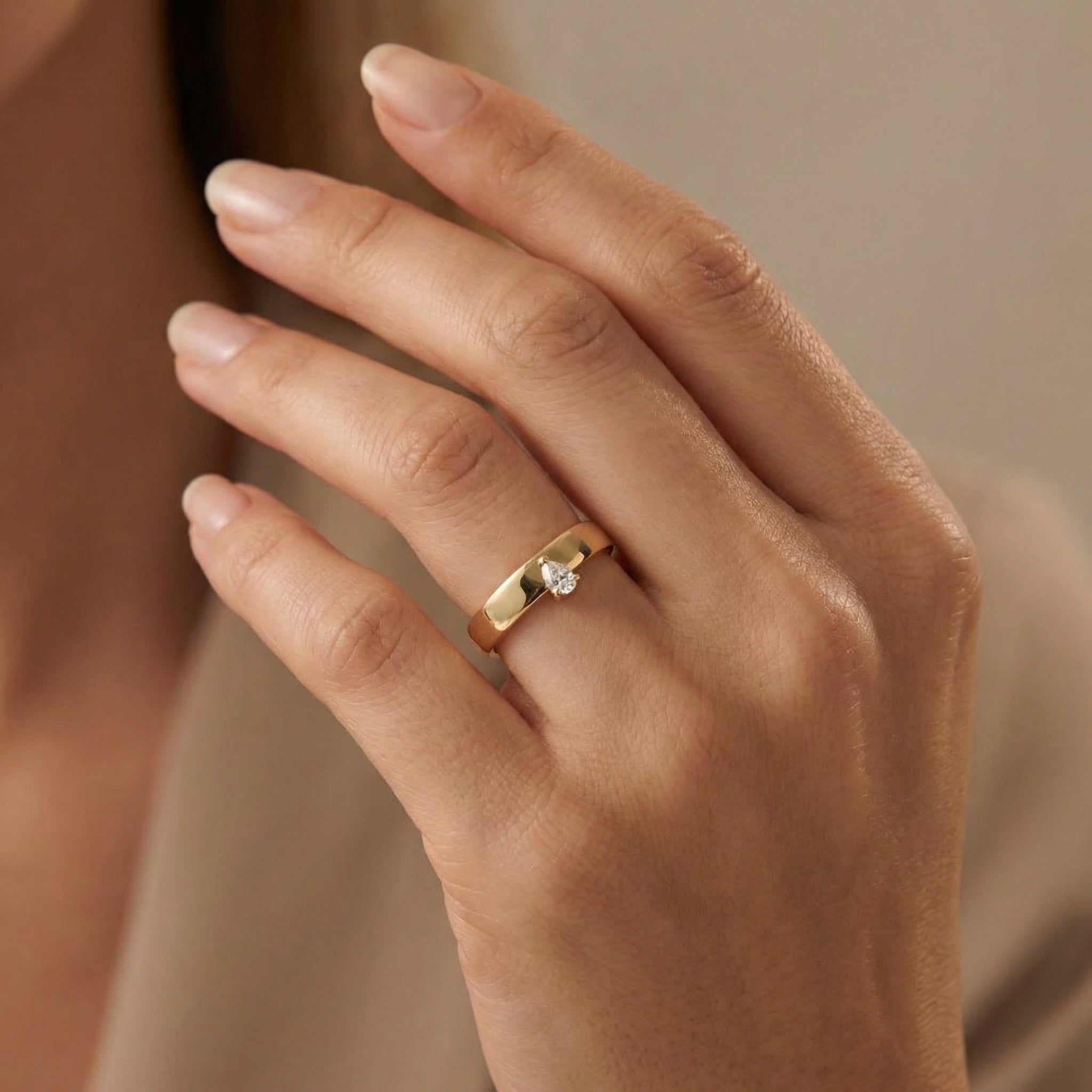 Modern smooth gold ring set with a teardrop-cut diamond
